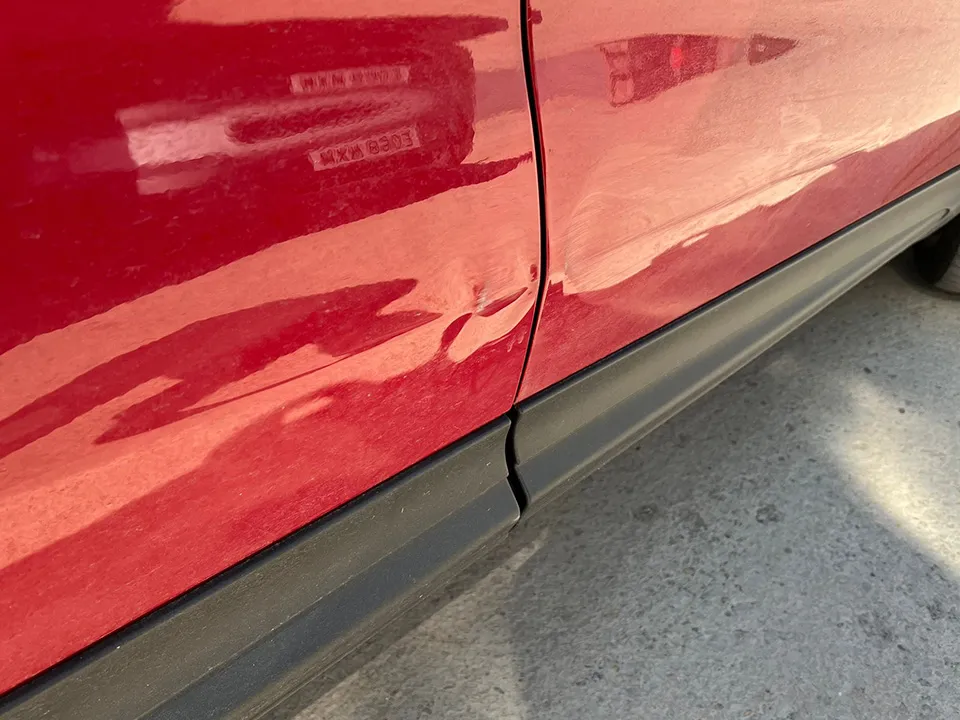Red Fiat 500X door crease and dent before repair at OH Works in Fairford
