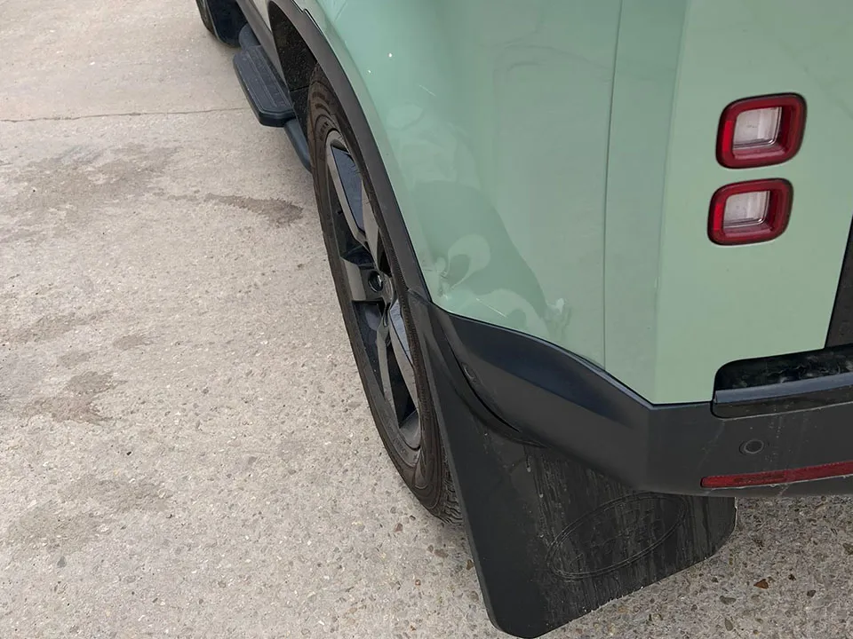 Green Land Rover Defender rear quarter damage before repair at OH Works in Fairford