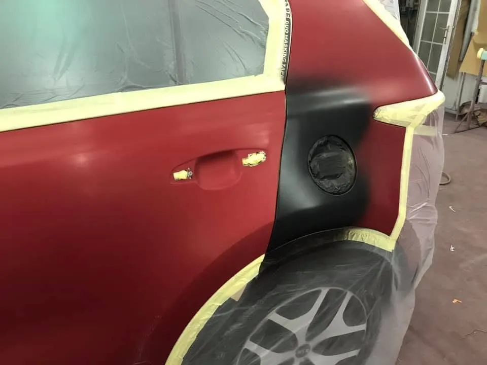Red Kia Sportage rear quarter damage before repair at OH Works in Fairford
