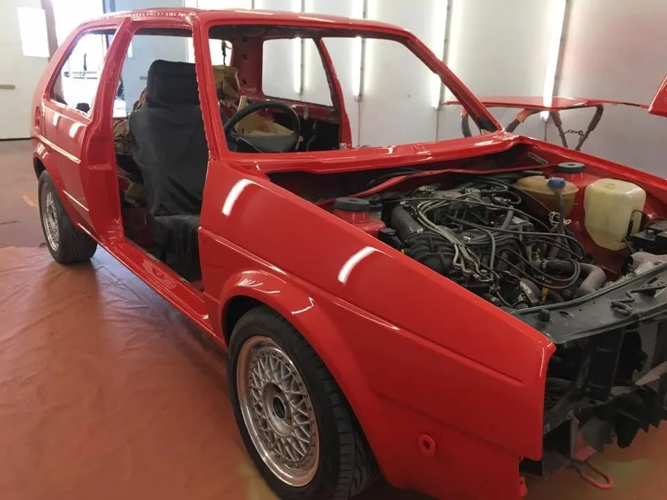 Red VW Golf during a full restoration at OH Works in Fairford